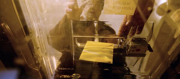 A person casts her ballot as part of the vote for the European elections on May 25, 2014 at a polling station in Tulle, central France. - Sputnik Afrique