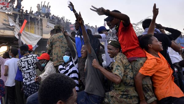 Sudanese demonstrators ride on a military truck as they chant slogans during a protest rally demanding Sudanese President Omar Al-Bashir to step down, outside Defence Ministry in Khartoum, Sudan April 9, 2019 - Sputnik Afrique