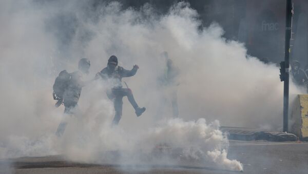 A protester throws back a tear gas canister during a demonstration called by the 'Yellow Vests' (gilets jaunes) movement, on April 13, 2019 in Toulouse. France has been rocked by months of weekly Saturday protests by the yellow vests, which emerged over fuel taxes before snowballing into a broad revolt against the French President. Pascal PAVANI / AFP - Sputnik Afrique