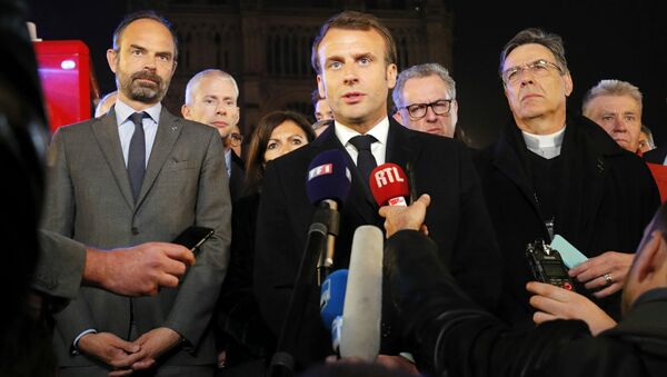 French President Emmanuel Macron (C) is accompanied by Mayor of Paris Anne Hidalgo (3L), French Prime Minister Edouard Philippe (L) French Culture Minister Franck Riester (2L) and Archbishop of Paris Michel Aupetit as he speaks at Notre-Dame Cathedral in Paris on April 15, 2019, after a fire engulfed the building. A fire broke out at the landmark Notre-Dame Cathedral in central Paris, potentially involving renovation works being carried out at the site, the fire service said.Images posted on social media showed flames and huge clouds of smoke billowing above the roof of the gothic cathedral, the most visited historic monument in Europe.  PHILIPPE WOJAZER / POOL / AFP - Sputnik Afrique