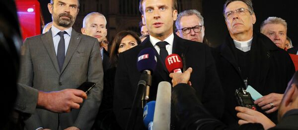 French President Emmanuel Macron (C) is accompanied by Mayor of Paris Anne Hidalgo (3L), French Prime Minister Edouard Philippe (L) French Culture Minister Franck Riester (2L) and Archbishop of Paris Michel Aupetit as he speaks at Notre-Dame Cathedral in Paris on April 15, 2019, after a fire engulfed the building. A fire broke out at the landmark Notre-Dame Cathedral in central Paris, potentially involving renovation works being carried out at the site, the fire service said.Images posted on social media showed flames and huge clouds of smoke billowing above the roof of the gothic cathedral, the most visited historic monument in Europe.  PHILIPPE WOJAZER / POOL / AFP - Sputnik Afrique