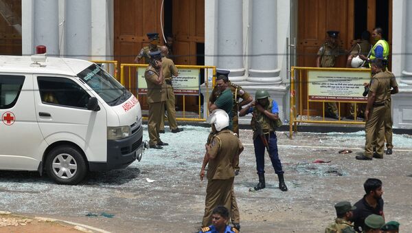 Sri Lankan security personnel stand next to an ambulance outside St. Anthony's Shrine in Kochchikade in Colombo on April 21, 2019 following a blast at the church. At least 42 people were killed April 21 in a string of blasts at hotels and churches in Sri Lanka as worshippers attended Easter services, a police official told AFP.  ISHARA S. KODIKARA / AFP - Sputnik Afrique