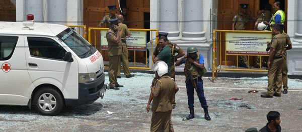 Sri Lankan security personnel stand next to an ambulance outside St. Anthony's Shrine in Kochchikade in Colombo on April 21, 2019 following a blast at the church. At least 42 people were killed April 21 in a string of blasts at hotels and churches in Sri Lanka as worshippers attended Easter services, a police official told AFP.  ISHARA S. KODIKARA / AFP - Sputnik Afrique