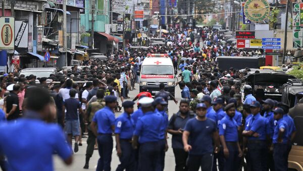 Sri Lankan police officers clear the road as an ambulance drives through carrying injured of Church blasts in Colombo, Sri Lanka, Sunday, April 21, 2019. A Sri Lanka hospital spokesman says several blasts on Easter Sunday have killed dozens of people. - Sputnik Afrique