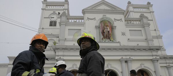 Sri Lankan firefighters stand in the area around St. Anthony's Shrine after a blast in Colombo, Sri Lanka, Sunday, April 21, 2019. - Sputnik Afrique