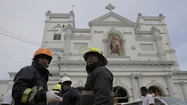 Sri Lankan firefighters stand in the area around St. Anthony's Shrine after a blast in Colombo, Sri Lanka, Sunday, April 21, 2019. - Sputnik Afrique
