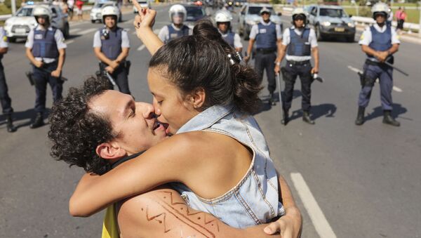 Пара целуется напротив заслона полиции во время забастовки Национального союза студентов в Бразилии - Sputnik Afrique