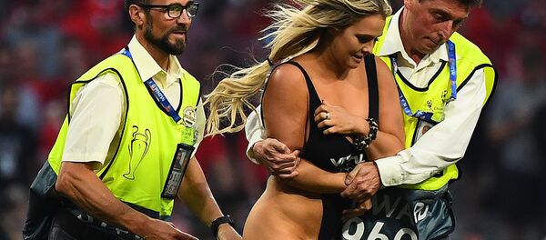 Stewards escort a pitch invader during the UEFA Champions League final football match between Liverpool and Tottenham Hotspur at the Wanda Metropolitano Stadium in Madrid on June 1, 2019 - Sputnik Afrique