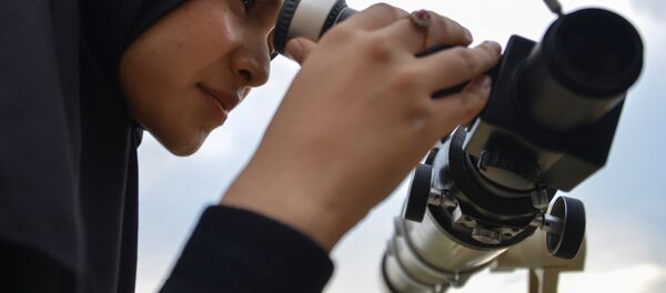 Une femme regarde dans un télescope pour observer la nouvelle lune - Sputnik Afrique