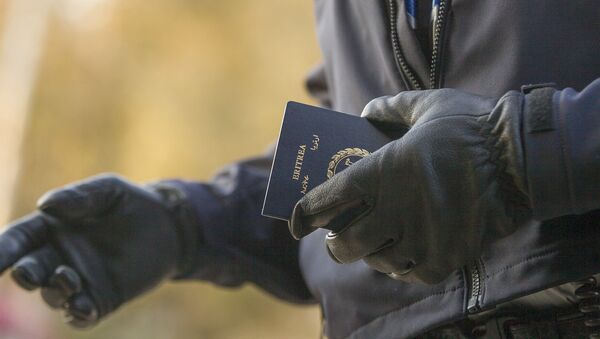 Un officier de la police aux frontières tient le passeport d'une femme érythréenne après son passage illégal de la frontière américano-canadienne - Sputnik Afrique