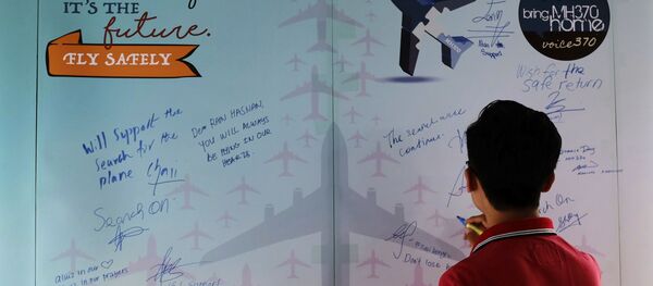 Un homme écrit un mot de condoléances lors de la journée de commémoration des victimes du MH370  - Sputnik Afrique