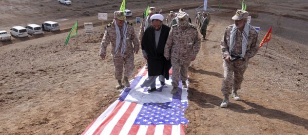 Des gardes de la révolution islamique et des représentants du clergé iranien marchent sur des drapeaux américain et israélien - Sputnik Afrique