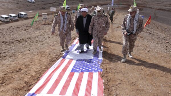 Des gardes de la révolution islamique et des représentants du clergé iranien marchent sur des drapeaux américain et israélien - Sputnik Afrique
