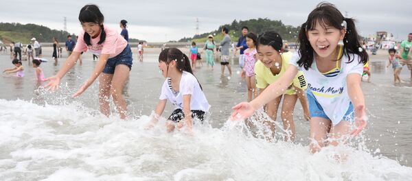 Des enfants jouent avec des vagues à la plage de Kitaizumi,  dans la préfecture de Fukushima, le 20 juillet 2019. - Sputnik Afrique