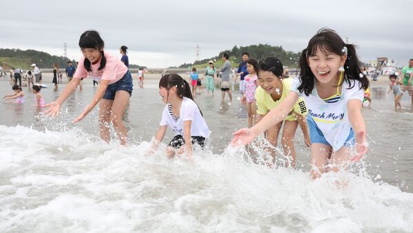 Des enfants jouent avec des vagues à la plage de Kitaizumi,  dans la préfecture de Fukushima, le 20 juillet 2019. - Sputnik Afrique