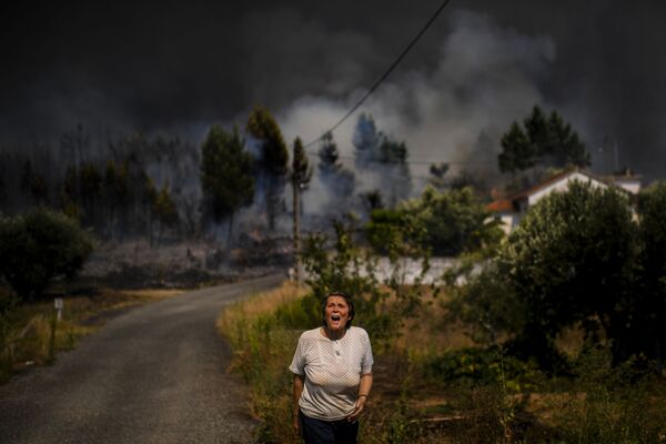Un habitant d'un village portugais dont la maison est entourée par un feu de forêt. - Sputnik Afrique