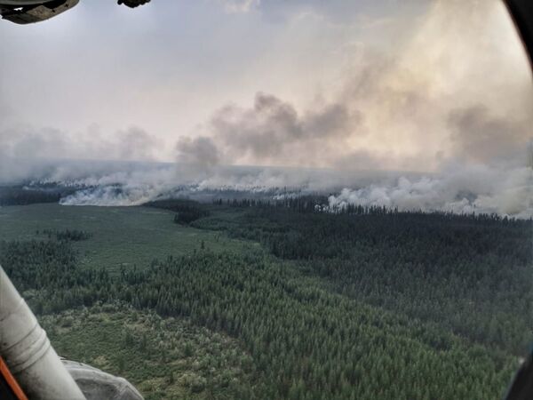 Fumée au-dessus des régions ravagées par les feux de forêt dans le district Verkhoyansky de la République de Sakha en Iakoutie - Sputnik Afrique