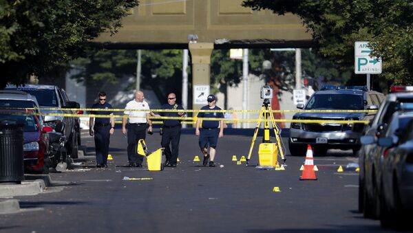 Authorities walk among evidence markers at the scene of a mass shooting, Sunday, Aug. 4, 2019, in Dayton, Ohio. Severral people in Ohio have been killed in the second mass shooting in the U.S. in less than 24 hours, and the suspected shooter is also deceased, police said - Sputnik Afrique