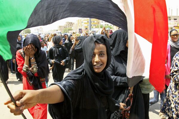 Une jeune Soudanaise avec le drapeau national lors des festivités à l’occasion de la signature de l’accord constitutionnel sur la formation d’un gouvernement de transition entre le conseil militaire et le front national de libération - Sputnik Afrique