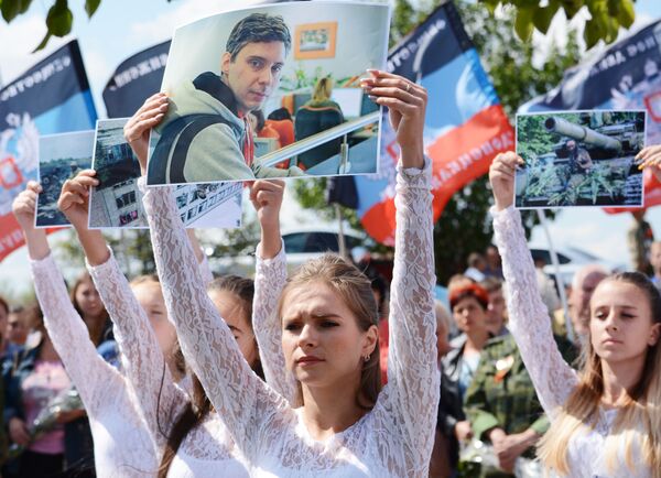 Des participants à la cérémonie de deuil dans la banlieue de Snejny, dans la République populaire autoproclamée de Donetsk, où est mort le photographe de l’agence Rossiya Segodnya Andréï Stenine - Sputnik Afrique