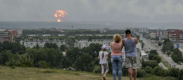 Une famille regarde les explosions dans un dépôt de munitions d'Atchinsk, en Sibérie (5 août 2019) - Sputnik Afrique