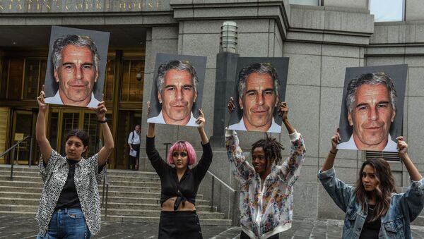 In this file photo taken on July 8, 2019, a protest group called Hot Mess hold up photos of Jeffrey Epstein in front of the Federal courthouse on July 8, 2019 in New York City. - Sputnik Afrique