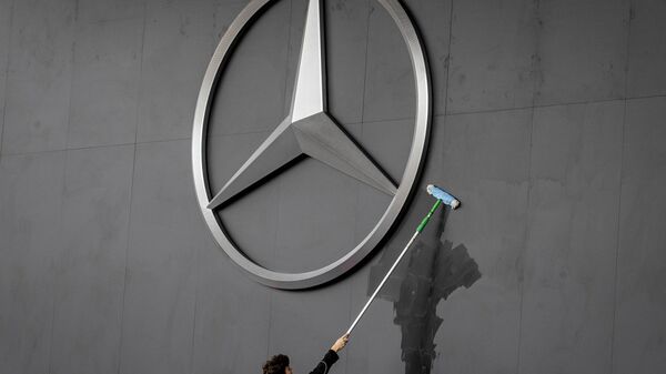 Работник протирает логотип Mercedes на автосалоне IAA во Франкфурте, Германия - Sputnik Afrique