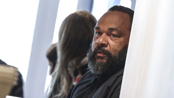 Controversial French comic Dieudonne M'bala M'bala looks on as he arrives at the Paris courthouse on March 26, 2019. - Dieudonne appears on March 26, 2019 in Paris over charges of tax evasion and money-laundering. (Photo by KENZO TRIBOUILLARD / AFP) - Sputnik Afrique