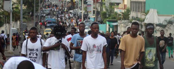 De jeunes Ivoiriens marchant dans une rue du Plateau, le quartier des affaires d’Abidjan - Sputnik Afrique