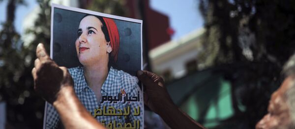 Un homme brandissant un portrait de Hajar Raissouni à Rabat Un homme brandissant un portrait de Hajar Raissouni à Rabat - Sputnik Afrique