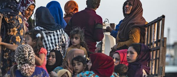 Syrian Arab and Kurdish civilians flee amid Turkish bombardment on Syria's northeastern town of Ras al-Ain in the Hasakeh province along the Turkish border on October 9, 2019. - Sputnik Afrique