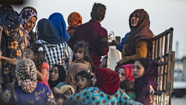 Syrian Arab and Kurdish civilians flee amid Turkish bombardment on Syria's northeastern town of Ras al-Ain in the Hasakeh province along the Turkish border on October 9, 2019. - Sputnik Afrique