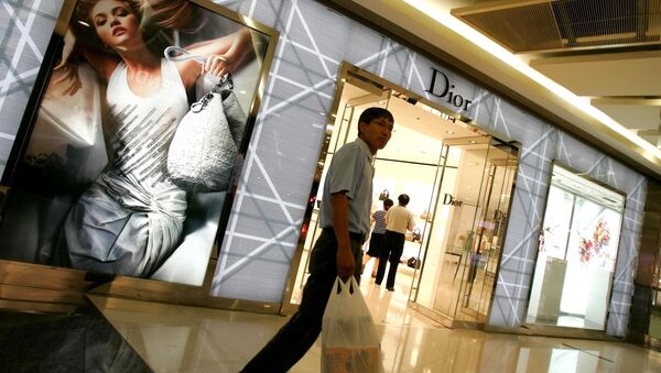 Un homme passe devant une boutique Dior à Pékin - Sputnik Afrique