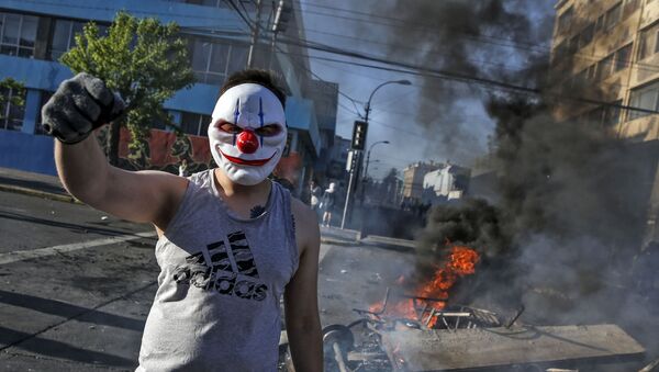 Демонстрант в маске во время протестов в Сантьяго, Чили - Sputnik Afrique