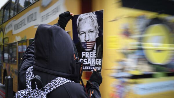 Un manifestant tient un tract demandant la libération de Julian Assange - Sputnik Afrique
