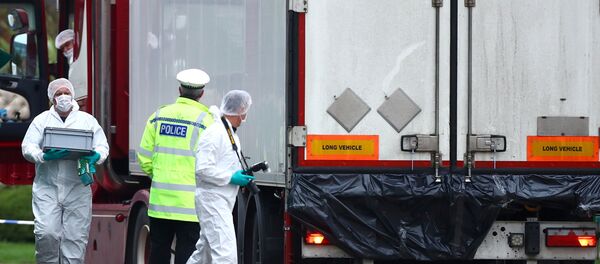 Police officers inspect the lorry in which 39 bodies were found - Sputnik Afrique
