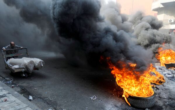 Manifestants brûlant des pneus dans une rue de Bagdad. - Sputnik Afrique