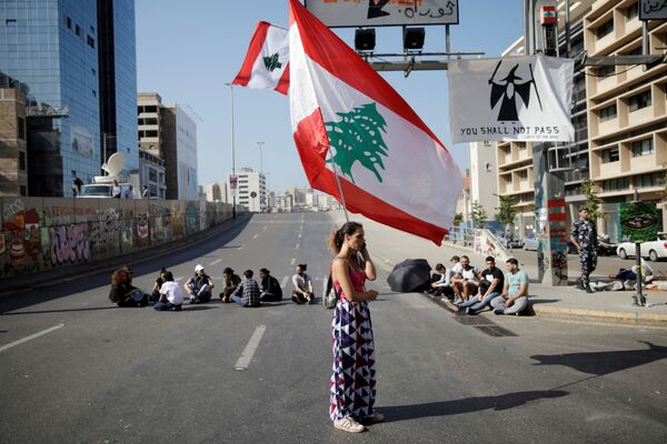 Manifestante tenant un drapeau libanais, Beyrouth. - Sputnik Afrique