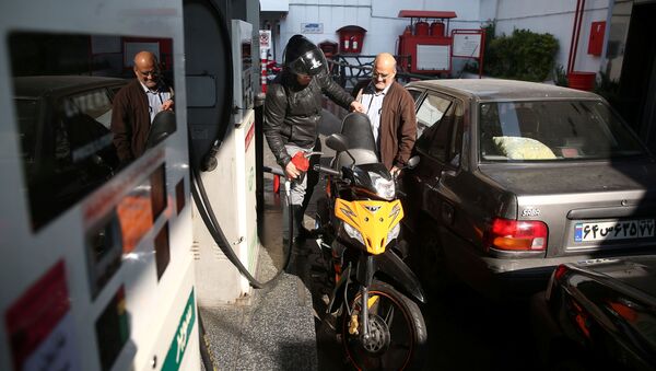 Un homme remplit le réservoir de sa moto dans une station-service, après que le prix de l'essence ait augmenté à Téhéran, en Iran, le 15 novembre 2019. - Sputnik Afrique