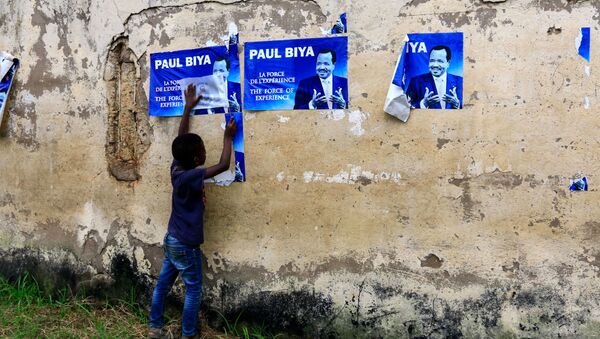 Un enfant devant des affiches électorales de Paul Biya - Sputnik Afrique