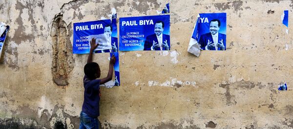 Un enfant devant des affiches électorales de Paul Biya - Sputnik Afrique
