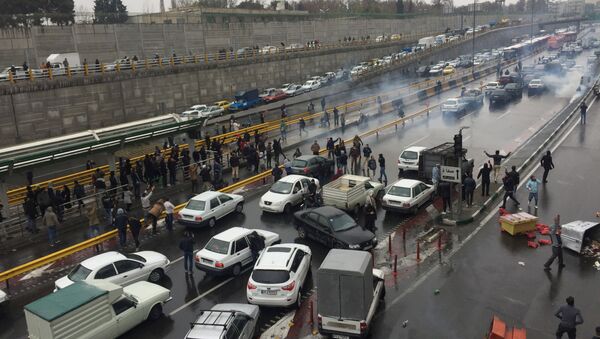 Des personnes arrêtent leurs voitures sur une autoroute pour manifester contre l'augmentation du prix de l'essence à Téhéran, en Iran, le 16 novembre 2019 - Sputnik Afrique