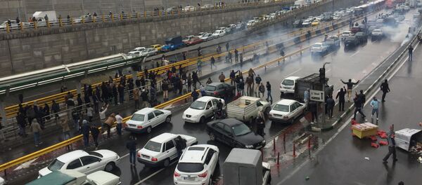 Des personnes arrêtent leurs voitures sur une autoroute pour manifester contre l'augmentation du prix de l'essence à Téhéran, en Iran, le 16 novembre 2019 - Sputnik Afrique