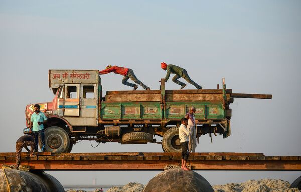 Ouvriers contruisant un pont flottant provisoire enjambant le Gange à Allahabad, Inde. - Sputnik Afrique