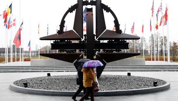 People hold umbrellas outside NATO headquarters in Brussels, Belgium, November 26, 2019 - Sputnik Afrique