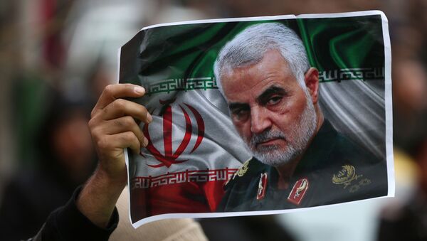 An Iranian holds a picture of late General Qassem Soleimani, head of the elite Quds Force, who was killed in an air strike at Baghdad airport, as people gather to mourn him in Tehran, Iran January 4, 2020.  - Sputnik Afrique