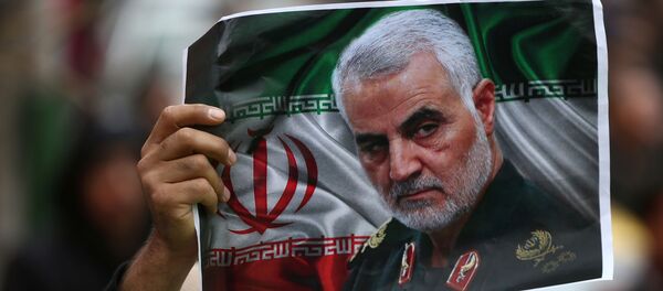 An Iranian holds a picture of late General Qassem Soleimani, head of the elite Quds Force, who was killed in an air strike at Baghdad airport, as people gather to mourn him in Tehran, Iran January 4, 2020.  - Sputnik Afrique