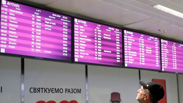 A man looks at the electronic board, which displays information on flights including the one from Tehran marked as cancelled, at the Boryspil International Airport outside Kiev, Ukraine January 8, 2020. - Sputnik Afrique