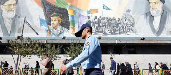 Un militaire iranien passe devant des photos du guide suprême iranien, l'ayatollah Ali Khamenei - Sputnik Afrique
