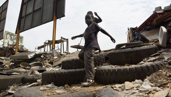 Des enfants descendent un escalier de fortune fait à base de pneus dans une décharge sauvage. - Sputnik Afrique